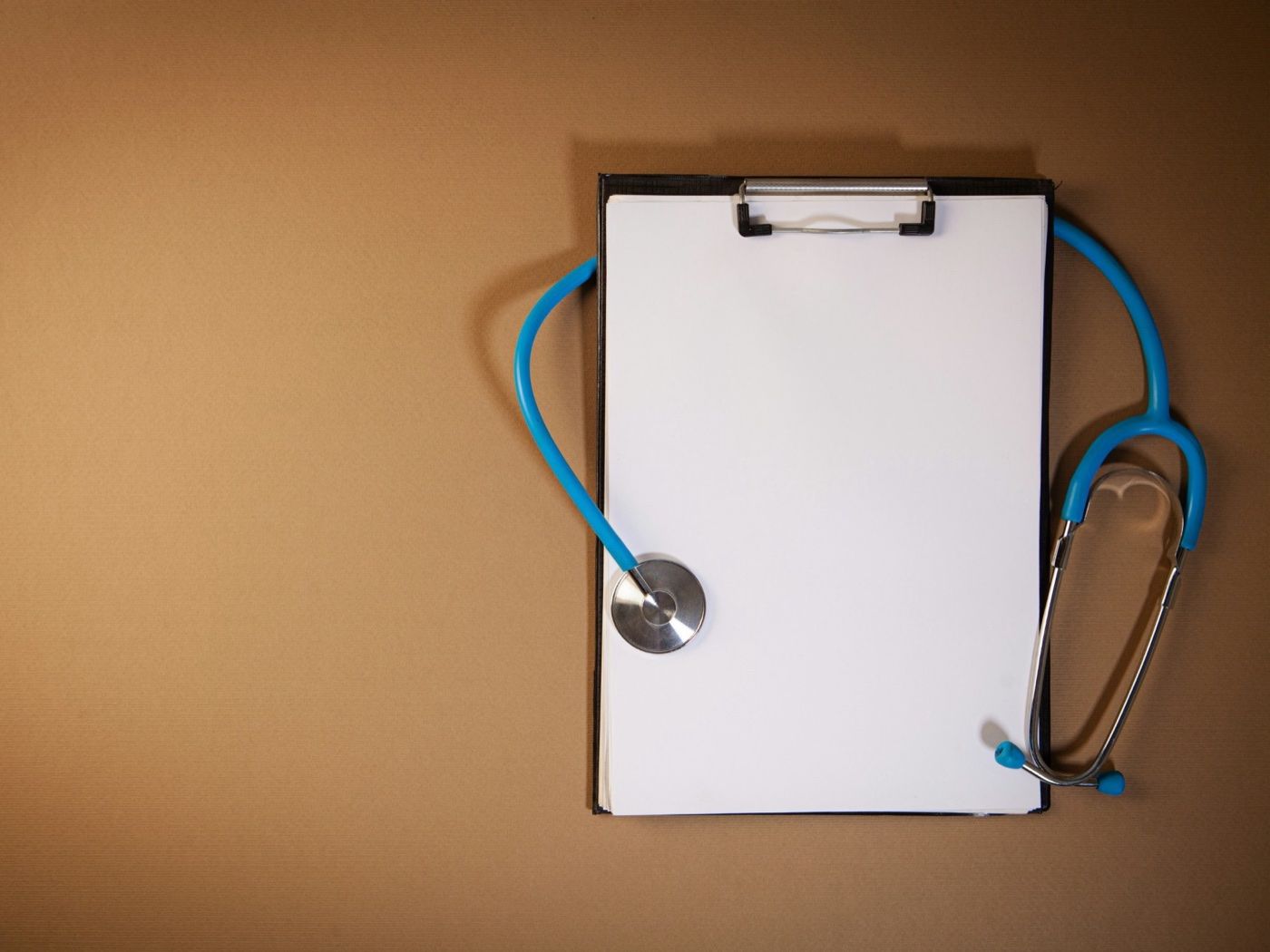 A stethoscope resting on a clipboard